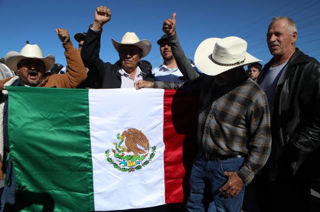Truckers carrying export goods to the United States hold a Mexican flag during a demonstration as part of the national farmers' strike, at the Zaragoza-Ysleta International Bridge in Ciudad Juarez, Chihuahua State, Mexico on November 24, 2025. (Photo by HERIKA MARTINEZ / AFP)