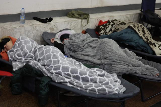 People take shelter at a metro station during Russian air attacks in Kyiv on November 25, 2025, amid the Russian invasion of Ukraine. Powerful explosions rocked Ukraine's capital Kyiv, an AFP journalist heard, as the air force issued a countrywide missile warning early November 25, 2025. (Photo by Yan Dobronosov / AFP)