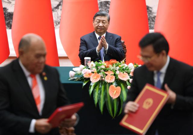 China’s President Xi Jinping applauds during a signing ceremony with Tonga's King Tupou VI (not pictured) at the Great Hall of the People in Beijing on November 25, 2025. (Photo by Maxim Shemetov / POOL / AFP)