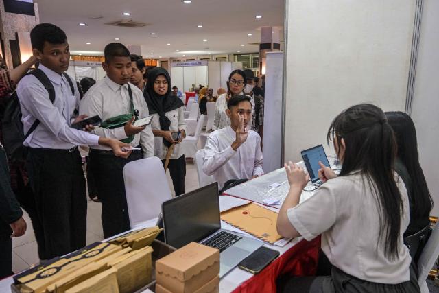 Physically challenged candidates wait to submit their application forms during a job fair organised by the government for people with disabilities in Surabaya, East Java province on November 25, 2025. (Photo by JUNI KRISWANTO / AFP)