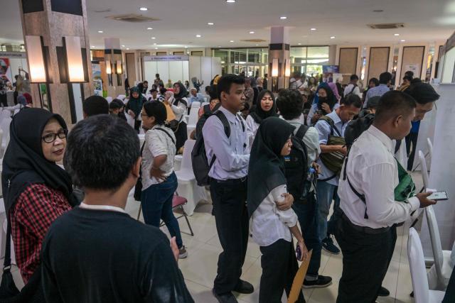Physically challenged candidates wait to submit their application forms during a job fair organised by the government for people with disabilities in Surabaya, East Java province on November 25, 2025. (Photo by JUNI KRISWANTO / AFP)