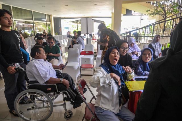 Physically challenged candidates wait to submit their application forms during a job fair organised by the government for people with disabilities in Surabaya, East Java province on November 25, 2025. (Photo by JUNI KRISWANTO / AFP)