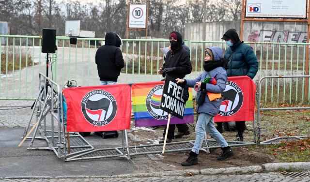 Demonstrators protest prior to the start of a trial of seven accused left extremists for membership in a criminal organisation on November 25, 2025 at the Higher Regional Court of Dresden, eastern Germany. The seven defendants are alleged members of the 'Antifa East' gang suspected of attacks on right-wing extremist. (Photo by MATTHIAS RIETSCHEL / POOL / AFP)