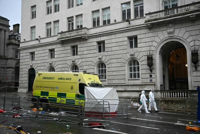 (FILES) Police forensics officers work at the scene on Water Street in Liverpool, north-west England on May 27, 2025, where a car ploughed in to crowds that had gathered on May 26 to watch an open-top bus victory parade for Liverpool's Premier League trophy parade. A British man is due to go on trial on November 25, 2025 accused of driving his car into crowds at Liverpool Football Club's Premier League victory parade in May and injuring dozens of people. Paul Doyle, 54, has pleaded not guilty to 31 alleged offences, including charges of causing grievous bodily harm (GBH) with intent, wounding with intent, affray and dangerous driving. (Photo by Paul ELLIS / AFP)