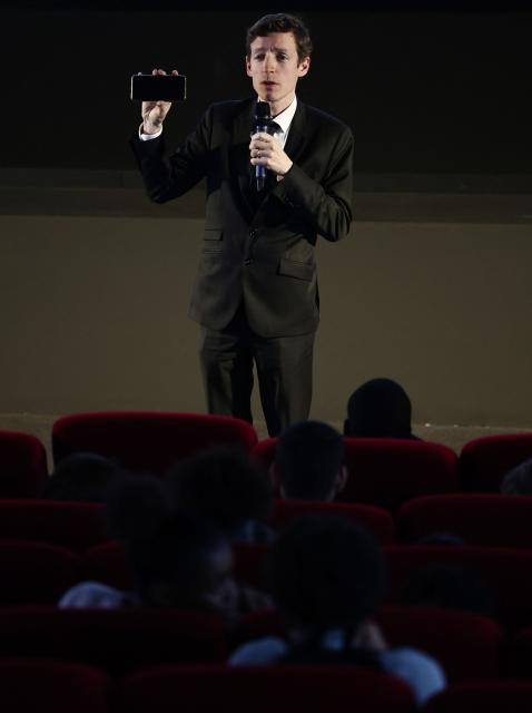 France's Education Minister Edouard Geffray speaks to students holding a phone up ahead of a school screening of the movie "Capitaines !" as part of a visit to the Cinemas du Palais movie theatre to unveil new measures promoting film education, in Creteil, Paris suburb on November 25, 2025. (Photo by Thibaud MORITZ / AFP)
