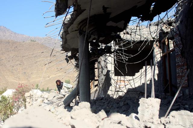 An Afghan man walks at a damaged house after an air strike by Pakistan, at Asadabad in Kunar province on November 25, 2025. Afghanistan's Taliban government vowed it would respond "appropriately at the right time" to alleged Pakistan border strikes that killed 10 people, as tensions soar following a suicide bombing in Peshawar. (Photo by Aimal Zahir / AFP)