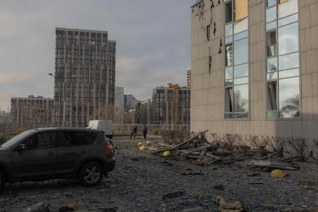Communal workers clean debris at the foot of a damaged residential building following Russian missiles and drones strikes in Kyiv on November 25, 2025, amid Russian invasion in Ukraine. Russia rained missiles and drones overnight on Kyiv, killing six people, authorities said on November 25, 2025, as three people died in Russia's Rostov region in massive Ukrainian strikes. (Photo by Roman PILIPEY / AFP)