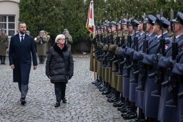 French Minister of the Armed Forces Catherine Vautrin (C) and Poland's Minister of Defence Wladyslaw Kosiniak-Kamysz 2nd L) review an honor guard during an official welcoming ceremony in front of the ministry building in Warsaw, Poland, on November 25, 2025. (Photo by Wojtek RADWANSKI / AFP)