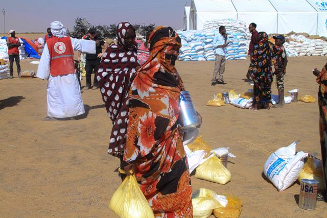 Sudanese women who fled El-Fasher receive humanitarian aid at the Al-Afad camp for displaced people in the town of Al-Dabba, northern Sudan, on November 25, 2025. Sudan's army said on November 25 it had repelled a Rapid Support Forces attack on a strategic city in southern Kordofan, a day after the RSF declared a unilateral three-month ceasefire. In a statement, the military, which has been at war with the RSF since April 2023, said its troops had "pushed back an assault" on an infantry base in the town of Babanusa. (Photo by Ebrahim HAMID / AFP)