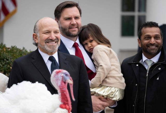 (L/R) US Commerce Secretary Howard Lutnick, Vice President JD Vance holding his daughter Mirabel, and FBI Director Kash Patel look on after US President Donald Trump pardoned Gobble, one of the National Thanksgiving turkeys, during the turkey pardon ceremony in the Rose Garden of the White House in Washington, DC on November 25, 2025. (Photo by ANDREW CABALLERO-REYNOLDS / AFP)