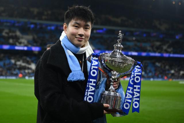 Chinese snooker player Zhao Xintong poses with the world trophy ahead of the UEFA Champions League league-stage football match between Manchester City and Bayer Leverkusen at the Etihad Stadium in Manchester, north west England, on November 25, 2025. (Photo by Oli SCARFF / AFP)