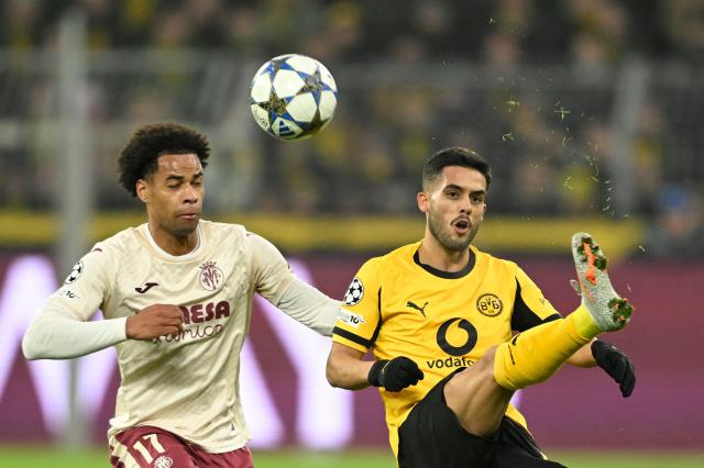 Villarreal's Canadian midfielder #17 Tajon Buchanan (L) and Dortmund's Brazilian defender #02 Yan Couto vie for the ball during the UEFA Champions League league phase day 5 football match between Borussia Dortmund and Villareal CF in Dortmund, on November 25, 2025. (Photo by INA FASSBENDER / AFP)