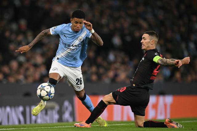 Manchester City's Brazilian midfielder #26 Savinho (L) vies with Bayer Leverkusen's Spanish defender #20 Alejandro Grimaldo (R) during the UEFA Champions League league-stage football match between Manchester City and Bayer Leverkusen at the Etihad Stadium in Manchester, north west England, on November 25, 2025. (Photo by Oli SCARFF / AFP)