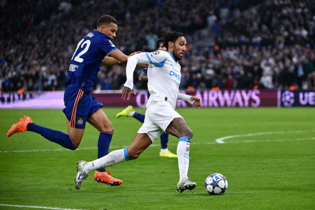 Marseille's Gabonese forward #97 Pierre-Emerick Aubameyang (R) fights for the ball with Newcastle United's German defender #12 Malick Thiaw  during the UEFA Champions League, league phase - matchday 5, football match between Olympique de Marseille (OM) and Newcastle United FC at the Velodrome Stadium in Marseille, southeastern France, on November 25, 2025. (Photo by Christophe SIMON / AFP)