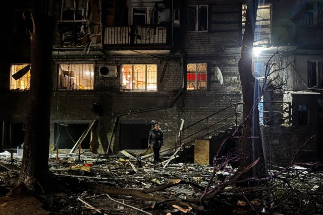 A woman walks through the courtyard of a damaged residential building following an air attack in Zaporizhzhia on November 25, 2025, amid the Russian invasion of Ukraine. (Photo by Darya NAZAROVA / AFP)