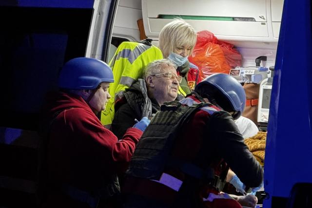 Emergency services provide assistance to a local resident following an air attack in Zaporizhzhia on November 25, 2025, amid the Russian invasion of Ukraine. (Photo by Darya NAZAROVA / AFP)