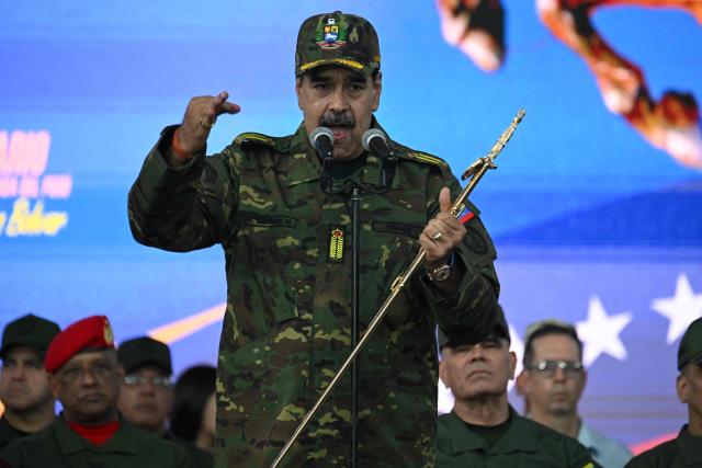 Venezuela's President Nicolas Maduro delivers a speech while holding the Venezuelan independence hero Simon Bolivar's 'Sword of Peru' during a military ceremony in Fuerte Tiuna, Caracas on November 25, 2025. (Photo by Federico PARRA / AFP)