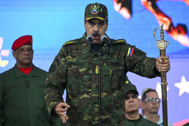 Venezuela's President Nicolas Maduro delivers a speech while holding the Venezuelan independence hero Simon Bolivar's 'Sword of Peru' during a military ceremony in Fuerte Tiuna, Caracas on November 25, 2025. (Photo by Federico PARRA / AFP)