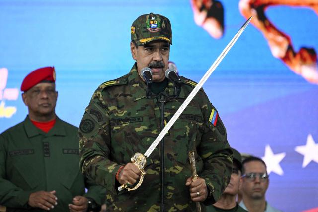 Venezuela's President Nicolas Maduro delivers a speech while holding the Venezuelan independence hero Simon Bolivar's 'Sword of Peru' during a military ceremony in Fuerte Tiuna, Caracas on November 25, 2025. (Photo by Federico PARRA / AFP)