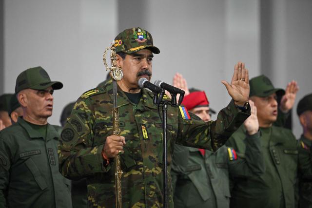 Venezuela's President Nicolas Maduro delivers a speech while holding the Venezuelan independence hero Simon Bolivar's 'Sword of Peru' during a military ceremony in Fuerte Tiuna, Caracas on November 25, 2025. (Photo by Federico PARRA / AFP)
