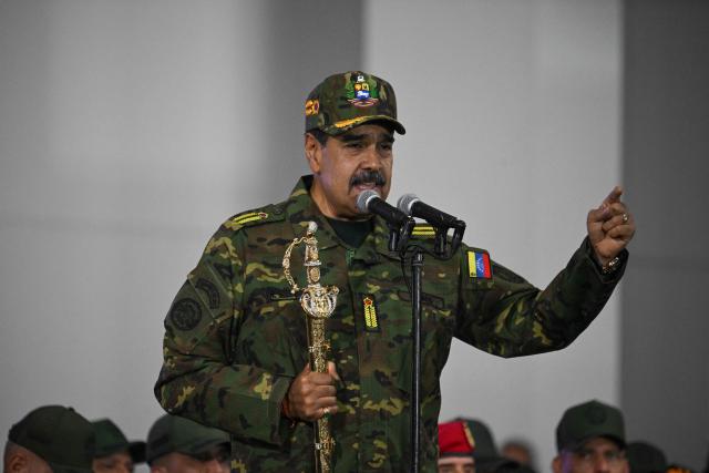 Venezuela's President Nicolas Maduro delivers a speech while holding the Venezuelan independence hero Simon Bolivar's 'Sword of Peru' during a military ceremony in Fuerte Tiuna, Caracas on November 25, 2025. (Photo by Federico PARRA / AFP)