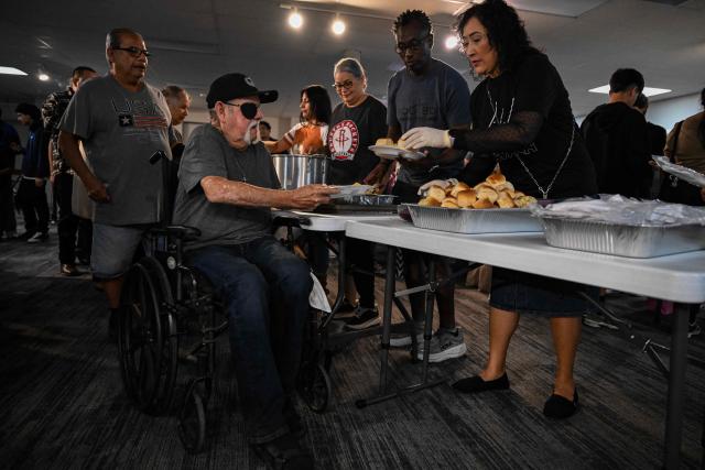 Volunteers serve food during the "Turkey and Blessing" dinner at Lindale Church in Houston on November 25, 2025, to celebrate the upcoming Thanksgiving holiday. (Photo by RONALDO SCHEMIDT / AFP)