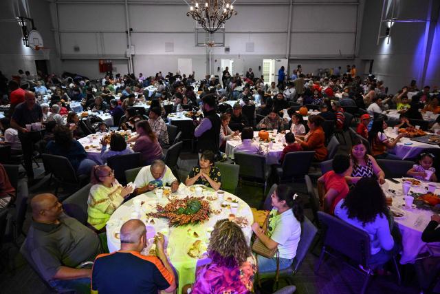 Volunteers serve food during the "Turkey and Blessing" dinner at Lindale Church in Houston on November 25, 2025, to celebrate the upcoming Thanksgiving holiday. (Photo by RONALDO SCHEMIDT / AFP)