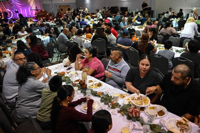 Volunteers serve food during the "Turkey and Blessing" dinner at Lindale Church in Houston on November 25, 2025, to celebrate the upcoming Thanksgiving holiday. (Photo by RONALDO SCHEMIDT / AFP)