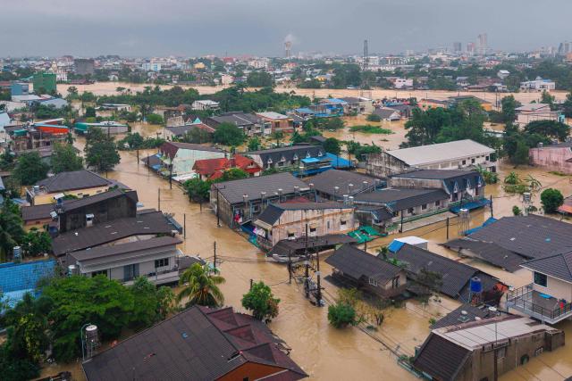 This aerial photo taken on November 26, 2025 shows flood waters surrounding residential buildings in Hat Yai in Thailand's southern Songkhla province, as severe flooding affected thousands of people in the country's south following days of heavy rain. A state of emergency was declared in Thailand's southern Songkhla province on November 25, as the meteorological department forecast more rain and possible flash floods this week. (Photo by Arnun Chonmahatrakool / THAI NEWS PIX / AFP)