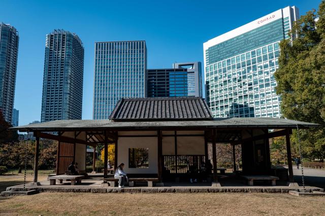 People rest in Hamarikyu Gardens in Tokyo on November 26, 2025. (Photo by Philip FONG / AFP)
