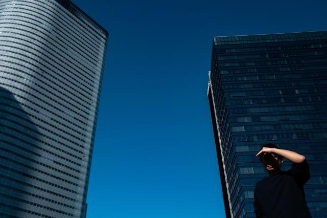 A pedestrian walks in the business area in Chuo district in Tokyo on November 26, 2025. (Photo by Philip FONG / AFP)