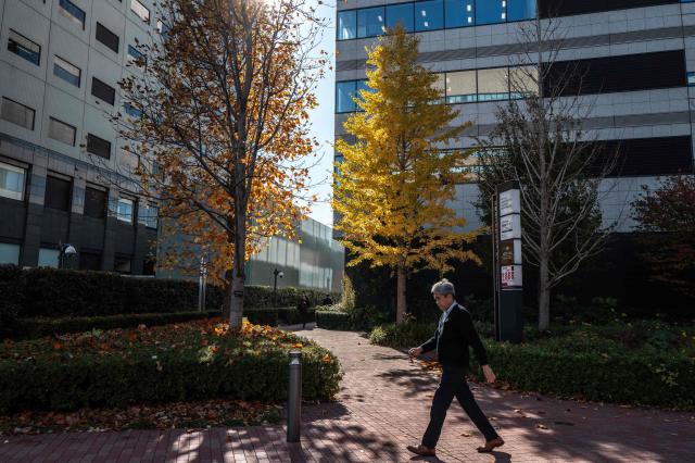 A pedestrian walks in the business area in Chuo district in Tokyo on November 26, 2025. (Photo by Philip FONG / AFP)