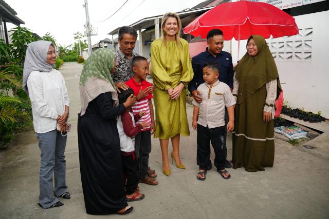Queen Maxima of the Netherlands (C), in her capacity as the UN Secretary General's Special Advocate for Financial Health (UNSGSA), poses for photos with residents during a visit to a subsidised housing complex for low-income families in Bekasi, West Java, on November 26, 2025. (Photo by Tatan Syuflana / POOL / AFP)