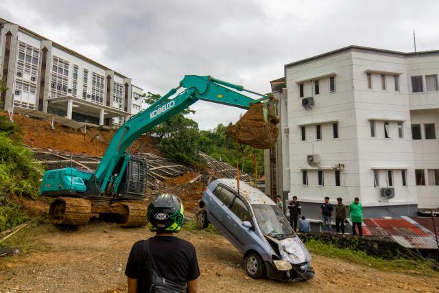 A rescue team evacuates a car damaged by a landslide that occurred at a university in Padang, West Sumatra on November 25, 2025. Floods and landslides killed at least eight people and injured dozens after torrential rains struck Indonesia's island of Sumatra, a disaster official said on November 26. (Photo by Ade Yuandha / AFP)