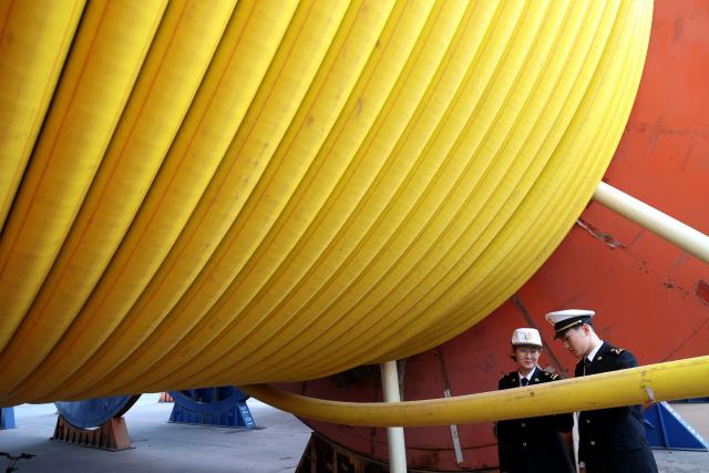 Workers inspect marine flexible pipes at a manufacturing facility in Binzhou, in China’s eastern Shandong province on November 26, 2025. (Photo by AFP) / China OUT