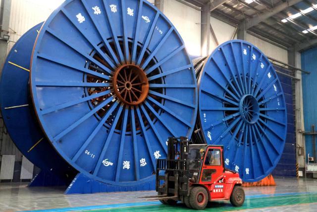 A worker operates a forklift at a marine flexible pipe manufacturing facility in Binzhou, in China’s eastern Shandong province on November 26, 2025. (Photo by AFP) / China OUT