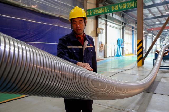 A worker inspects marine flexible pipes at a manufacturing facility in Binzhou, in China’s eastern Shandong province on November 26, 2025. (Photo by AFP) / China OUT