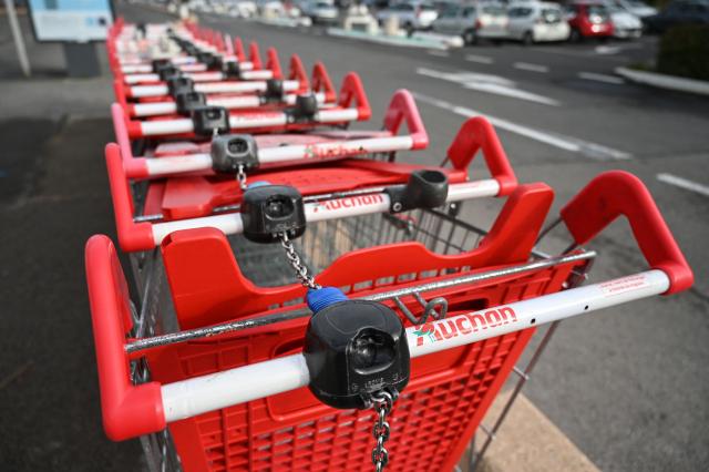 (FILES) Shopping trolleys are parked in front of the French supermarket  Auchan on January 14, 2020 in Perols, southwestern France. After several years of difficulties, French retailer Auchan announced on on November 25, 2025 that it plans to operate all of its approximately 300 French supermarkets (excluding Corsica) as franchises under the Intermarche and Netto banners. (Photo by Pascal GUYOT / AFP)
