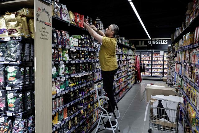 (FILES) An employee organises shelves of grocery products on display in an Intermarche supermarket prior to a visit of France's Minister of Labor, Health, Solidarities and Families in Paris on September 5, 2025. After several years of difficulties, French retailer Auchan announced on on November 25, 2025 that it plans to operate all of its approximately 300 French supermarkets (excluding Corsica) as franchises under the Intermarche and Netto banners. (Photo by STEPHANE DE SAKUTIN / AFP)