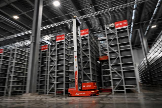 (FILES) An automated guided vehicle moves to pick up boxes with packages for delivery ahead of the Singles’ Day shopping festival which falls on November 11, at a JD.com warehouse in Beijing on November 9, 2021. Chinese e-commerce giant JD.com has accepted the conditions set by the French Ministry of Finance to become the second largest shareholder in Fnac Darty, France's Economy and Finance Minister Roland Lescure said on November 26, 2025 on French radio France Inter. (Photo by Jade GAO / AFP)