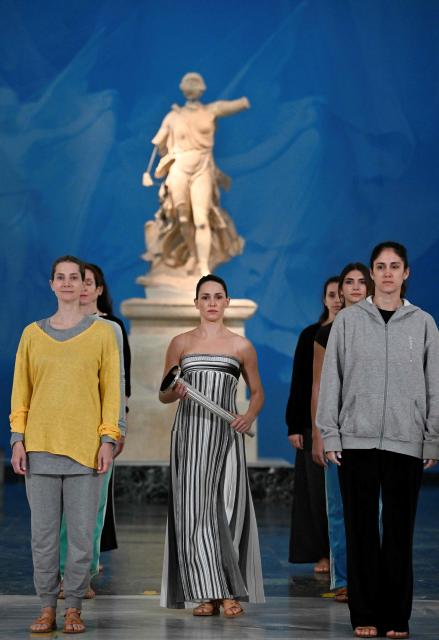 Greek actress Mary Mina on the role of High Priestess takes part in the flame lighting ceremony during a rehearsal of the lighting of the Olympic flame, for the Olympic Winter Games Milano Cortina 2026, at the Museum of ancient Olympia, in Olympia, on November 25, 2025. (Photo by Aris MESSINIS / AFP)