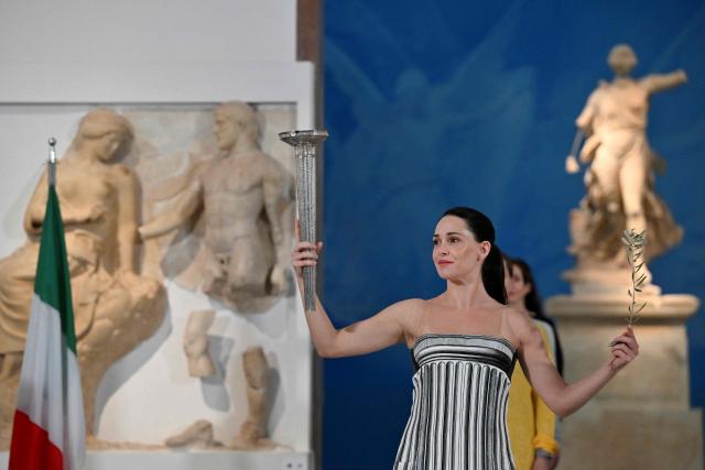 Greek actress Mary Mina on the role of High Priestess takes part in the flame lighting ceremony during a rehearsal of the lighting of the Olympic flame, for the Olympic Winter Games Milano Cortina 2026, at the Museum of ancient Olympia, in Olympia, on November 25, 2025. (Photo by Aris MESSINIS / AFP)