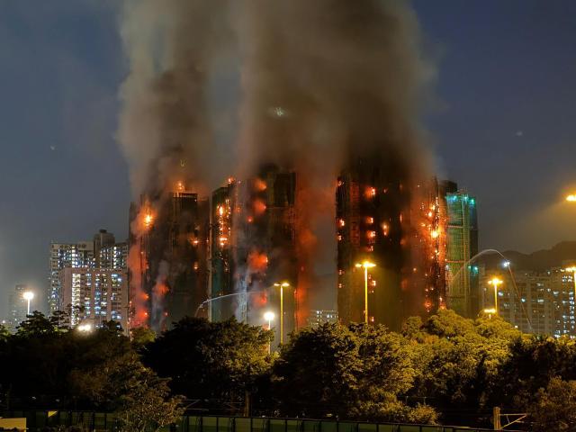 Thick smoke and flames rise as a major fire engulfs several apartment blocks at the Wang Fuk Court residential estate in Hong Kong's Tai Po district on November 26, 2025. At least four people were killed when a fire engulfed several high-rise blocks in a Hong Kong residential estate on November 26, the government said, with media reporting that some residents were trapped inside. (Photo by Yan ZHAO / AFP)