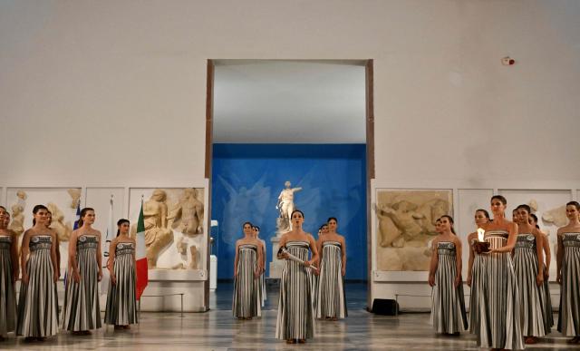 Greek actress Mary Mina (C), playing the role of the High Priestess, takes part in the flame lighting ceremony of the Olympic flame, for the Olympic Winter Games Milano Cortina 2026, at the Museum of ancient Olympia, in Olympia on November 26, 2025. (Photo by Aris MESSINIS / AFP)