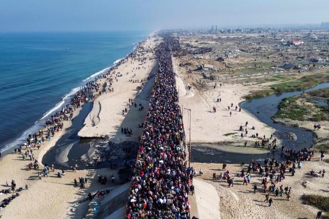 TOPSHOT - AFP PICTURES OF THE YEAR 2025

This aerial photo shows displaced Gazans walking toward Gaza City on January 27, 2025, after crossing the Netzarim corridor from the southern Gaza Strip.. An unending stream of people marched up the coast of Gaza on January 27, carrying their belongings in plastic bags and repurposed flour sacks through the central city of Nuseirat after Israel reopened access to the territory's north. (Photo by AFP) / AFP PICTURES OF THE YEAR 2025