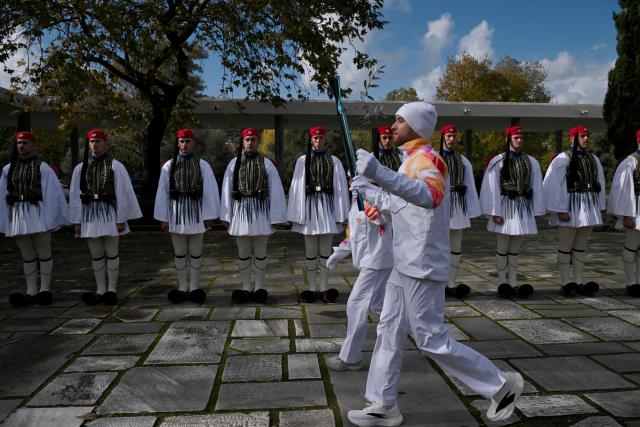 Performers take part in the flame lighting ceremony of the Olympic flame, for the Olympic Winter Games Milano Cortina 2026, at the Museum of ancient Olympia, in Olympia on November 26, 2025. (Photo by Aggelos NAKKAS / AFP)