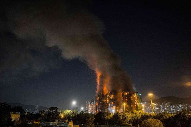 Thick smoke and flames rise as a major fire engulfs several apartment blocks at the Wang Fuk Court residential estate in Hong Kong's Tai Po district on November 26, 2025. At least four people were killed when a fire engulfed several high-rise blocks in a Hong Kong residential estate on November 26, the government said, with media reporting that some residents were trapped inside. (Photo by AFP)