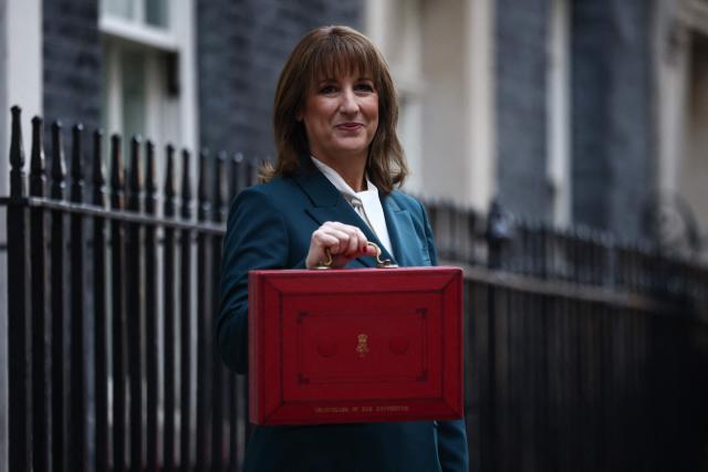 Britain's Chancellor of the Exchequer Rachel Reeves poses with the red Budget Box as she leaves 11 Downing Street, in central London on November 26, 2025, to present the government's annual Budget to Parliament. (Photo by Henry NICHOLLS / AFP)
