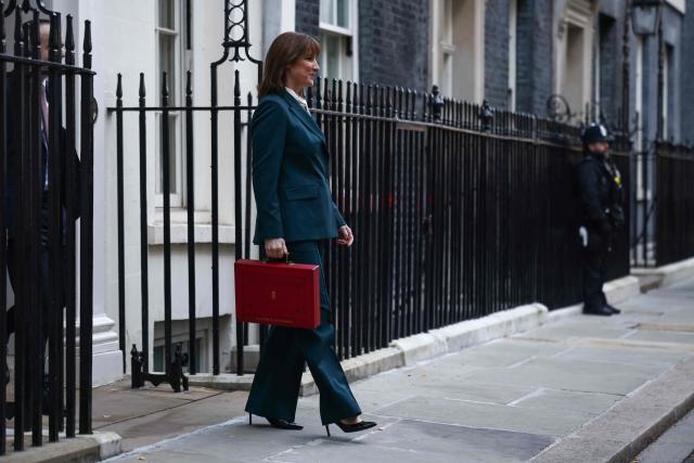 Britain's Chancellor of the Exchequer Rachel Reeves walks out with the red Budget Box as she leaves 11 Downing Street, in central London, on November 26, 2025, to present the government's annual Budget to Parliament. (Photo by Henry NICHOLLS / AFP)