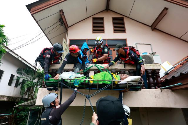 A man with a medical condition is evacuated by rescuers to be transported through flood waters in Hat Yai in Thailand's southern Songkhla province on November 26, 2025, as severe flooding affected thousands of people in the country's south following days of heavy rain. Tens of thousands of people in Thailand and neighbouring Malaysia were displaced by widespread flooding, with streets submerged, homes inundated and at least 34 dead, officials said November 26. (Photo by Sarot Meksophawannakul / THAI NEWS PIX / AFP)